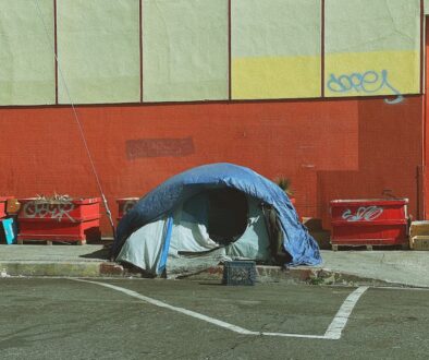 man in blue jacket lying on blue and white tent