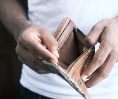 person holding brown leather bifold wallet