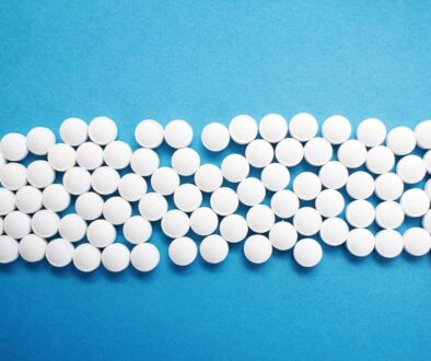 a group of white pills sitting on top of a blue surface