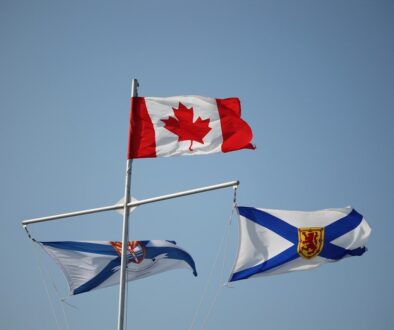 Canadian and nova scotian flags against a blue sky